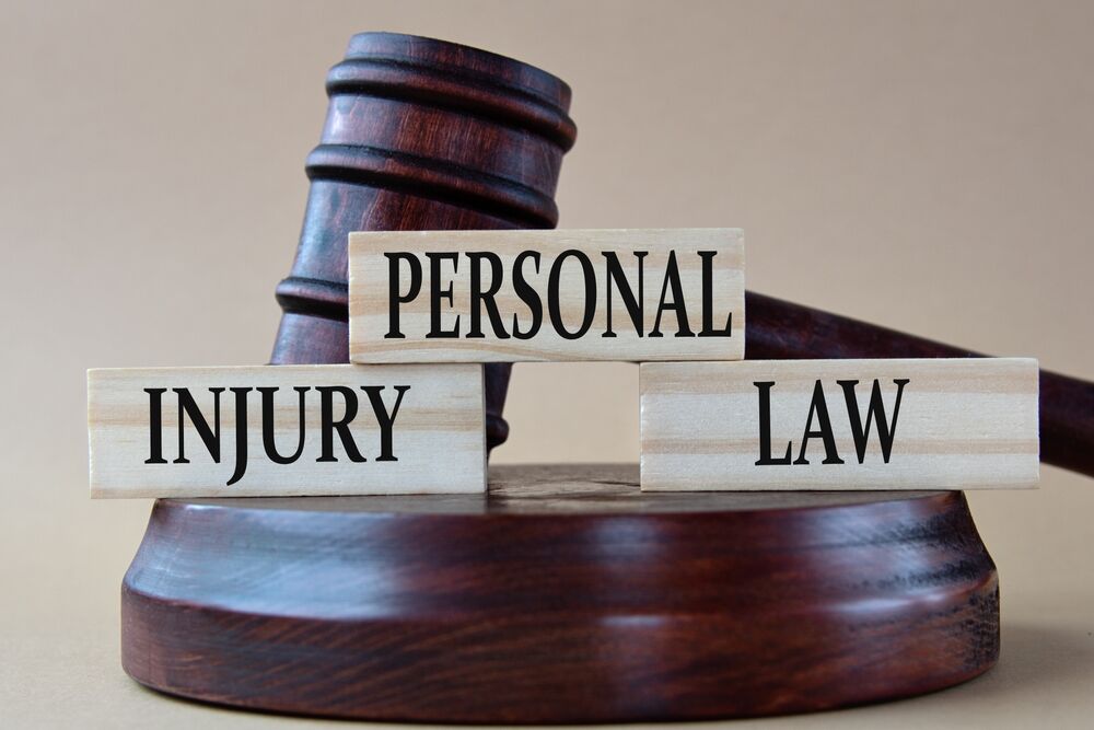 judge's gavel with wooden blocks in front reading PERSONAL INJURY LAW depicting personal injury law concept