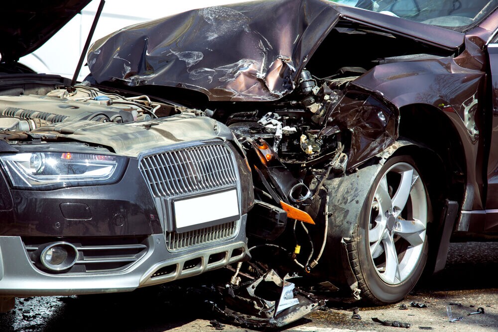 Head-on collision of two cars, close-up of damaged cars at the time of the accident.