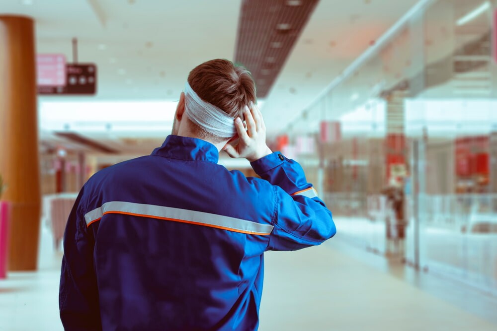 picture of construction worker from behind holding his bandaged head