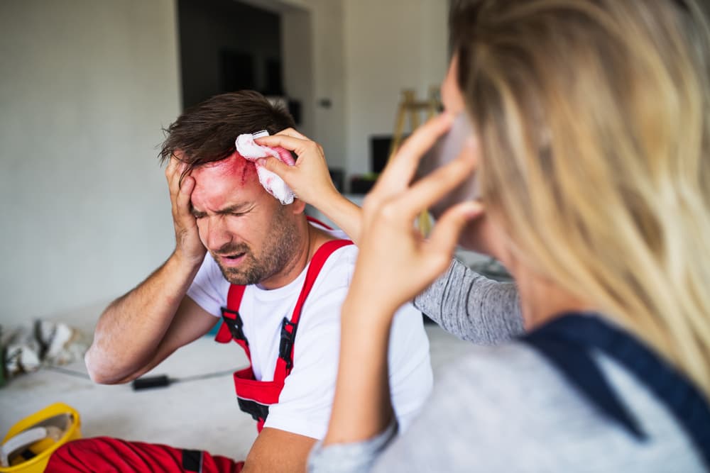 man holding head and bleeding while women on phone