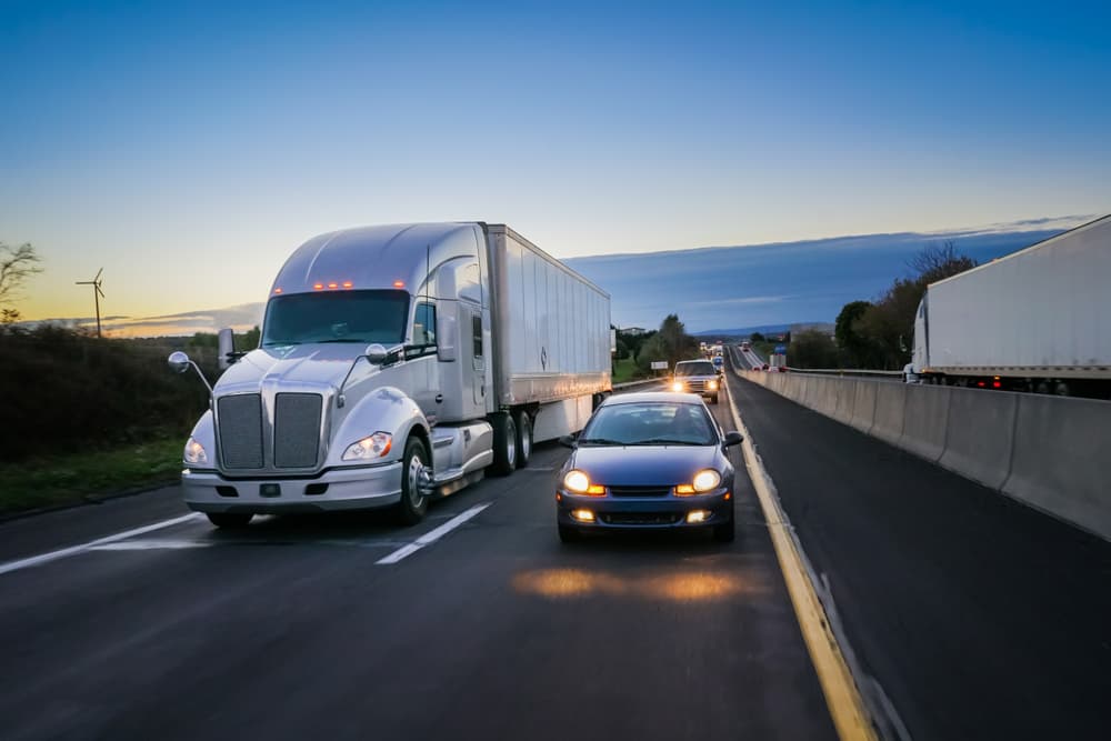 truck driving next to car