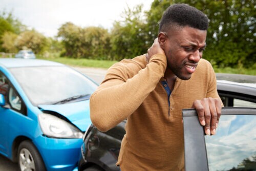 driver stepping out of auto accident with an injured neck