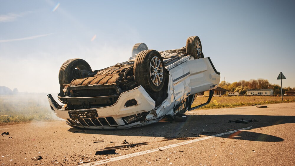 Horrific Traffic Accident, Rollover Smoking and Burning Vehicle Lying on its Roof in the Middle of the Road after Collision.