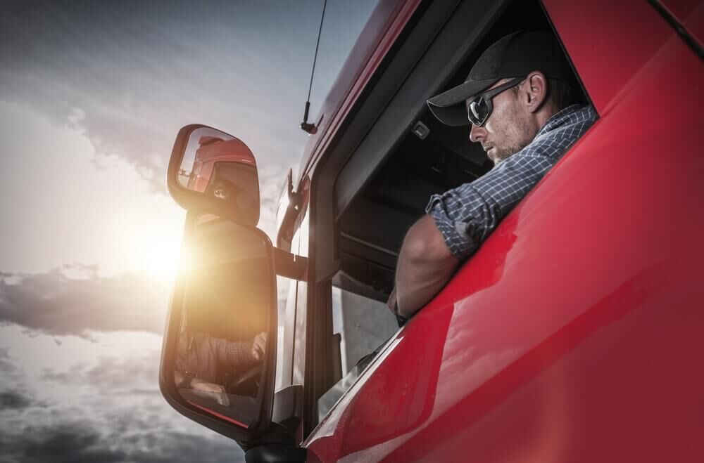 truck driver looking at the side mirror.