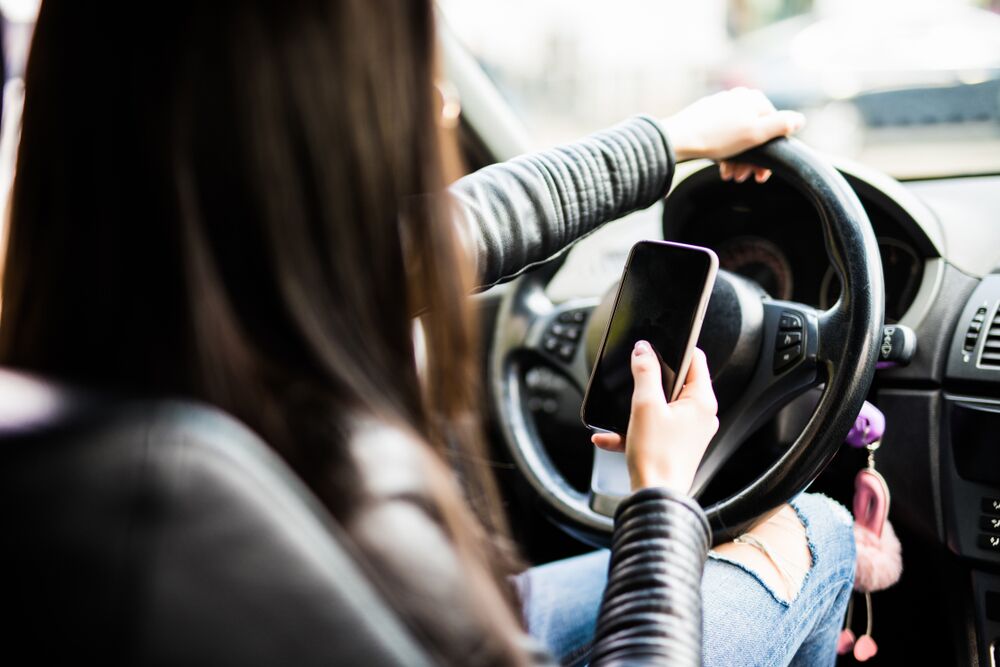 teen driver looking at phone while driving